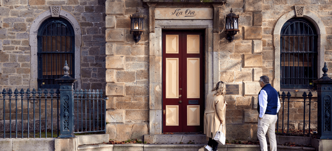 A couple are reading a plaque on the front of Kia Ora, a historical building located in Townsend Street, Albury